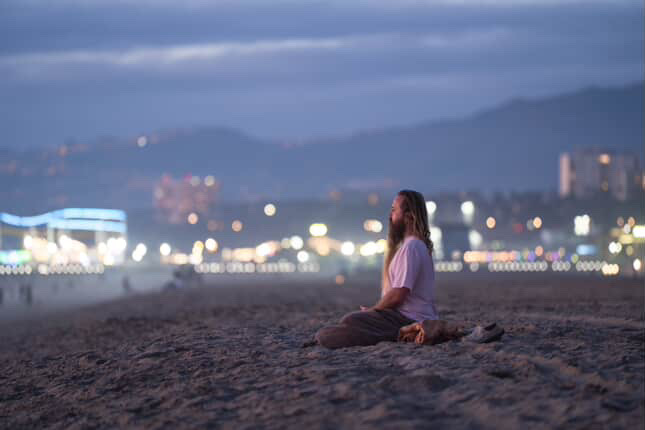 Adam Wes meditating at the ocean